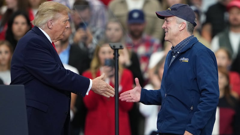 President Donald Trump greets Sen. Dan Sullivan, R-Alaska, at a campaign rally at the Curtis...