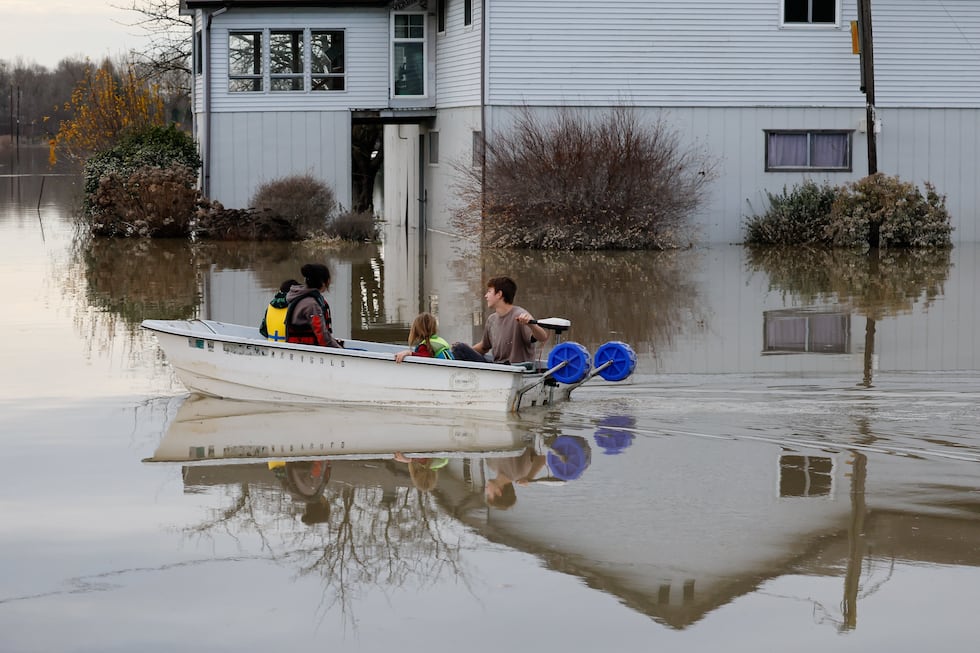 Carter Johnson, 16, uses a boat to transport his five-year-old brother, Milo, and two...