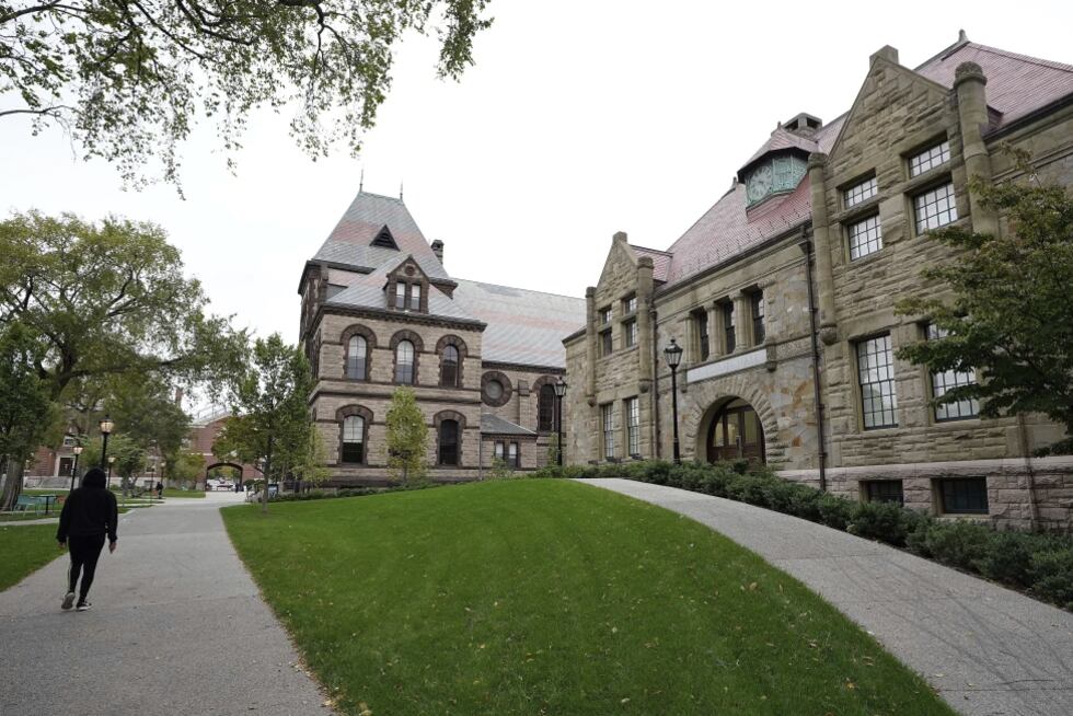 A pedestrian walks along a path on the campus of Brown University, in Providence, R.I.,...