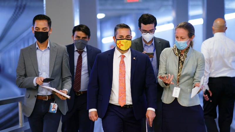 FILE - Sen. Ben Ray Lujan, D-N.M., center, arrives for votes on amendments to advance the $1...