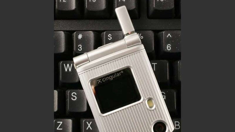 In this March 8, 2007, photo, a C3 flip-phone from Pantech is shown, on a keyboard for size...