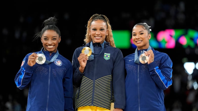Gold medalist Rebeca Andrade, center, of Brazil, celebrates on the podium between silver...