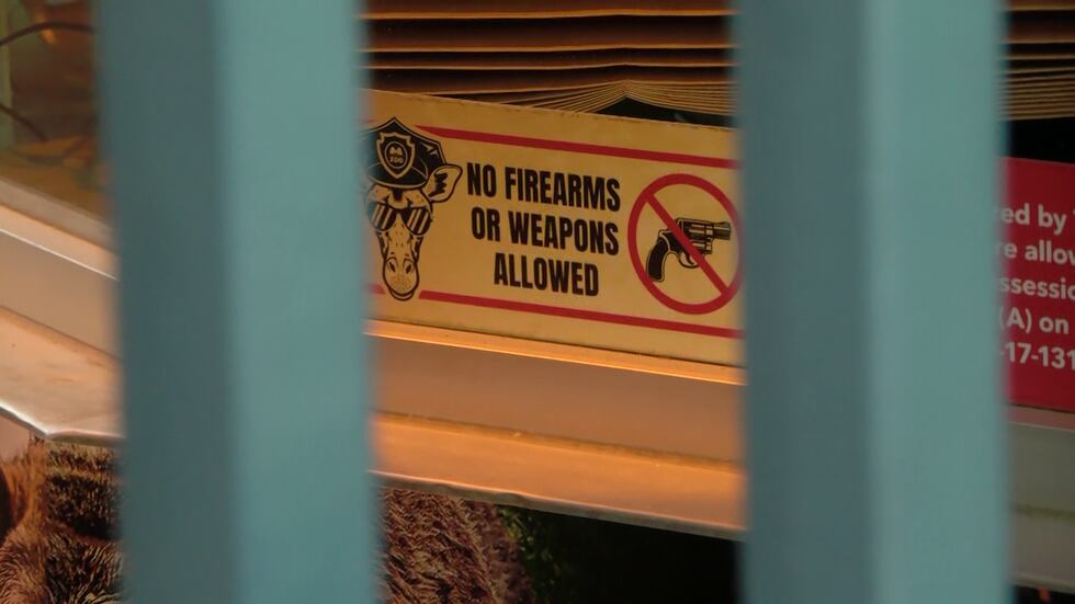 Sign posted outside the Memphis Zoo's ticket window reading, "No firearms or weapons allowed"