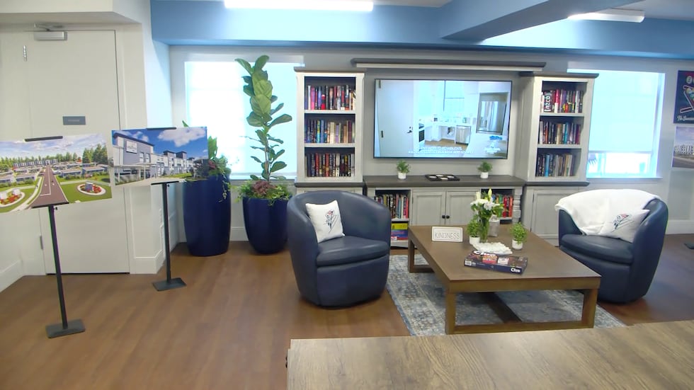 Interior of a supportive housing community room with comfortable seating, bookshelves, and a welcoming environment