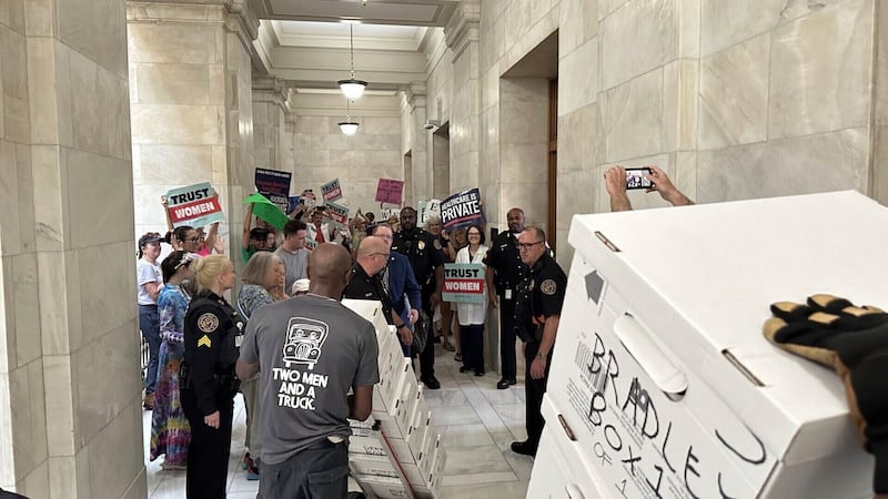 FILE - Boxes containing signatures supporting a proposed ballot measure to scale back...